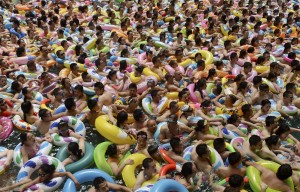 Visitors crowd an artificial wave swimming pool at a tourist resort to escape the summer heat in Daying county of Suining, Sichuan province, China, July 11, 2015. REUTERS/Stringer CHINA OUT. NO COMMERCIAL OR EDITORIAL SALES IN CHINA      TPX IMAGES OF THE DAY